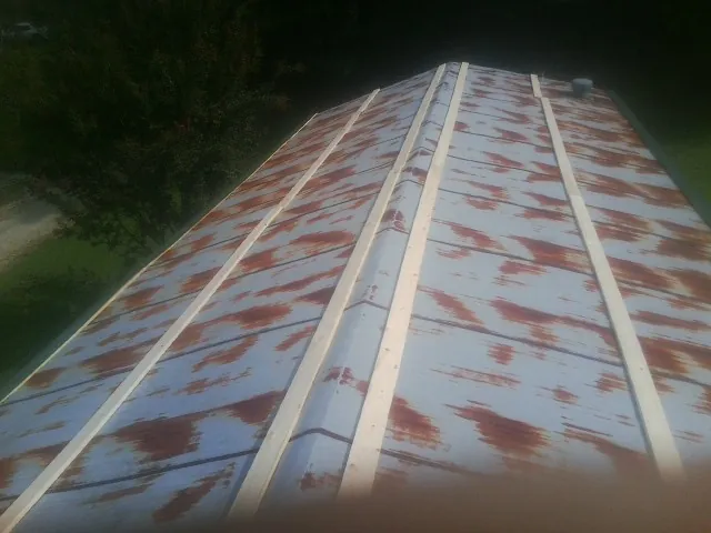 Rusted metal roof panels with new wood purlins before replacement — Storm Damage Roof Repair in Payne by Roofing Brothers