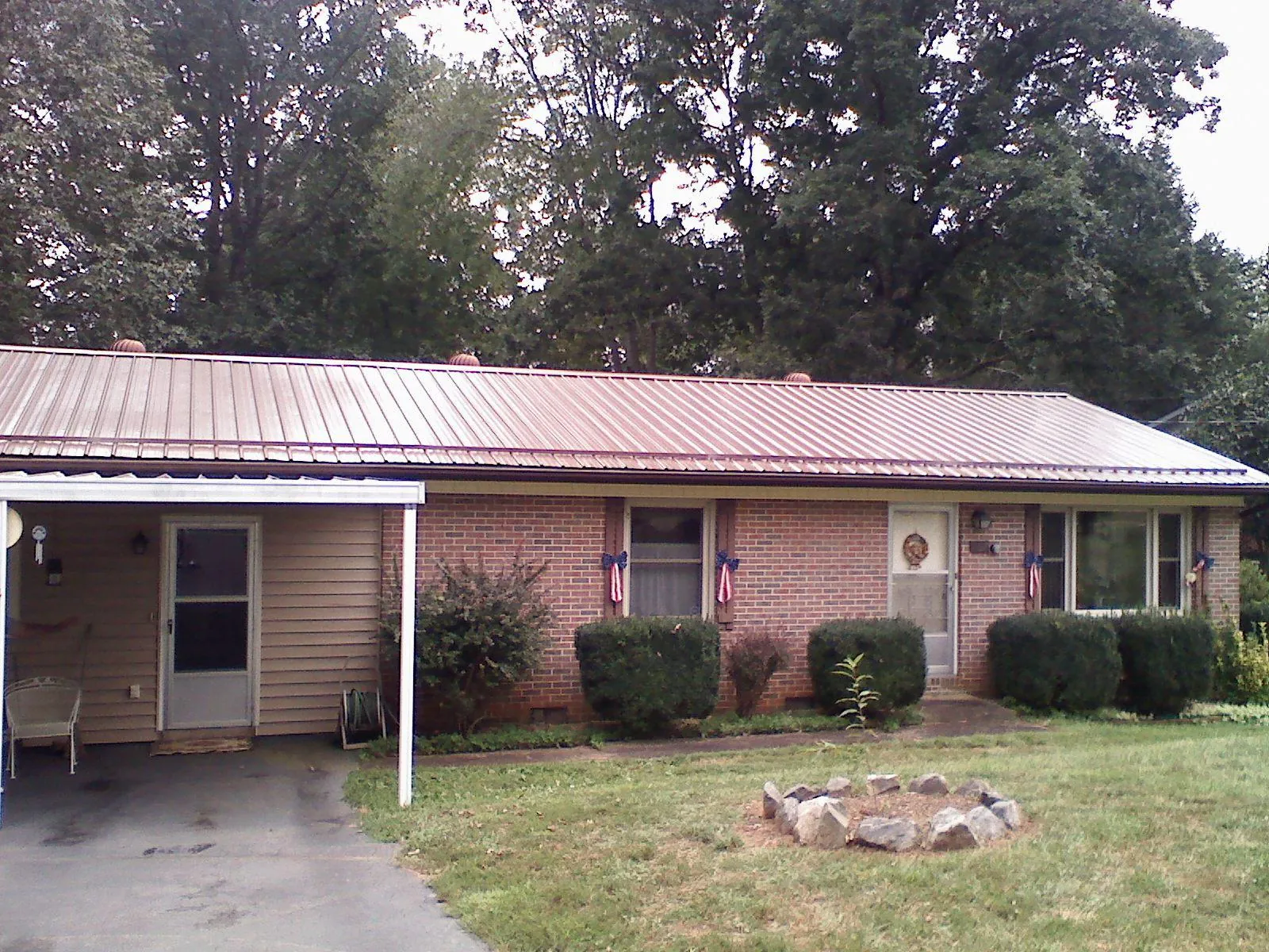 Bronze metal roof and carport on a brick ranch home — Roof Repair work by our crew in Payne